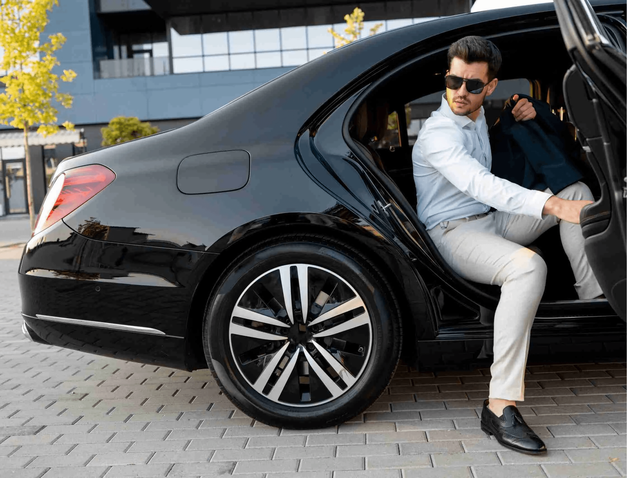 Passenger stepping out of a black Mercedes chauffeur vehicle in Birmingham