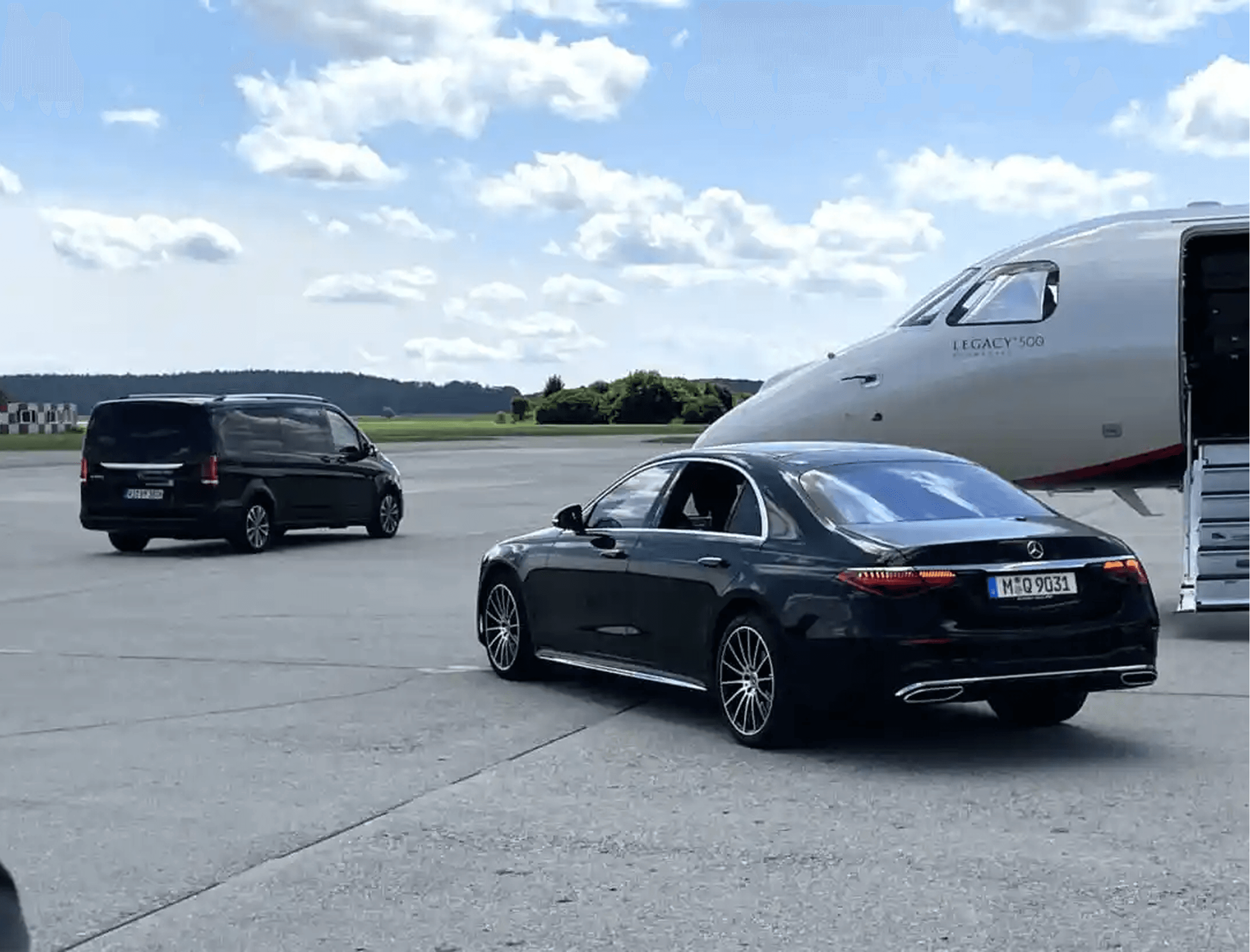 Luxury chauffeur vehicles waiting on the tarmac beside a private jet
