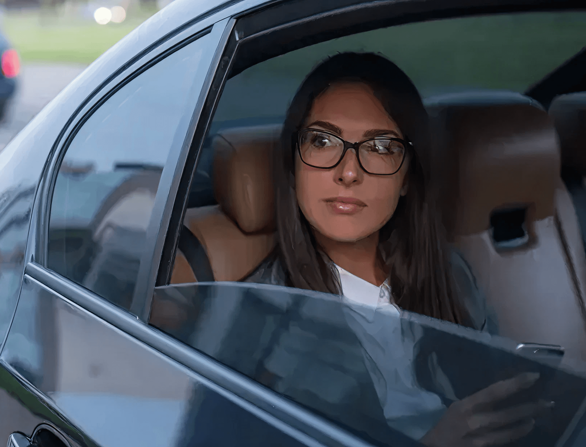 Passenger looking out of a chauffeur-driven car window near London